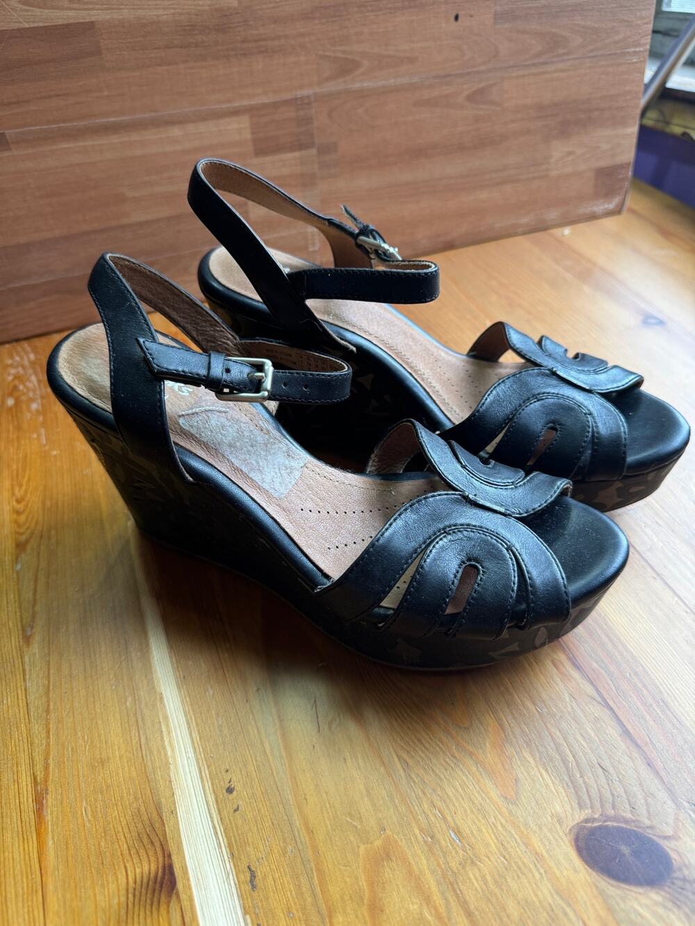 is Clarks Artisan "Amelia Page" Black Leather Floral Wedge Sandals.